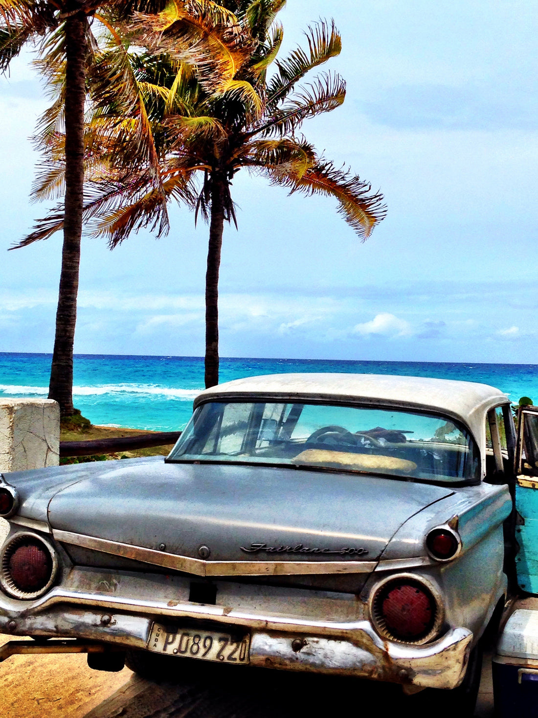 An Old American Car Alongside a Palm Tree on a Beautiful Beach in Varadero, Cuba.